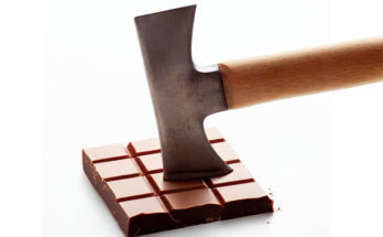 Cutting a square of chocolate with a hatchet.