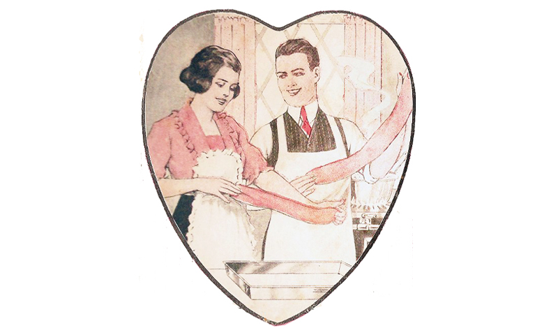 Young couple pulling pink taffy framed within a heart.